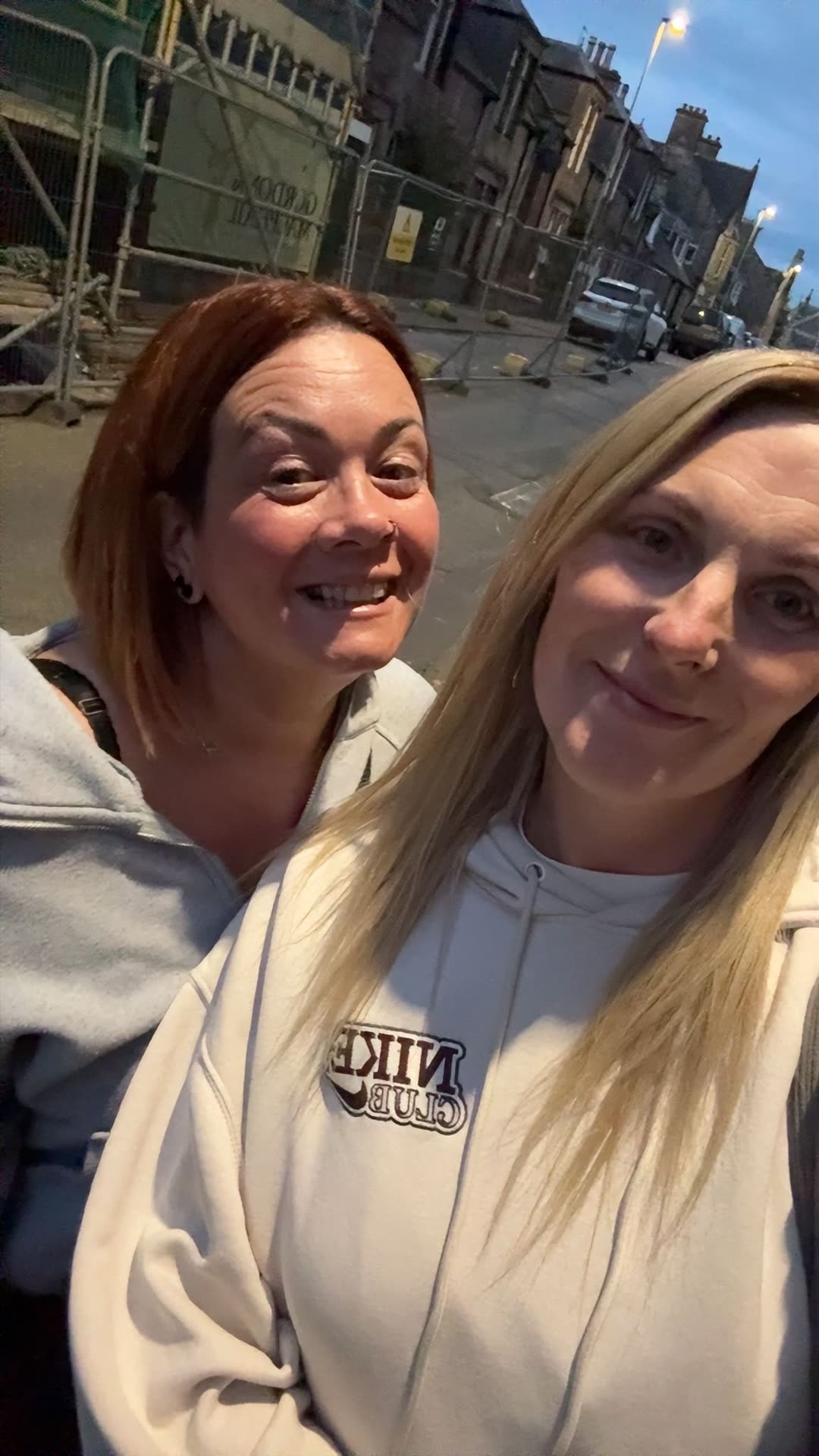 Gillian, on the right, out in town at dusk with a friend